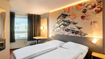 Habitación de hotel con cama, escritorio y un gran mural en la pared de un edificio tradicional.