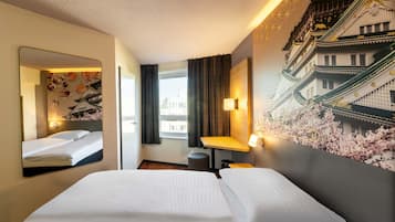 Ein Hotelzimmer mit zwei Betten, einem großen Spiegel, einem an der Wand montierten Fernseher und einem Fenster mit Vorhängen.