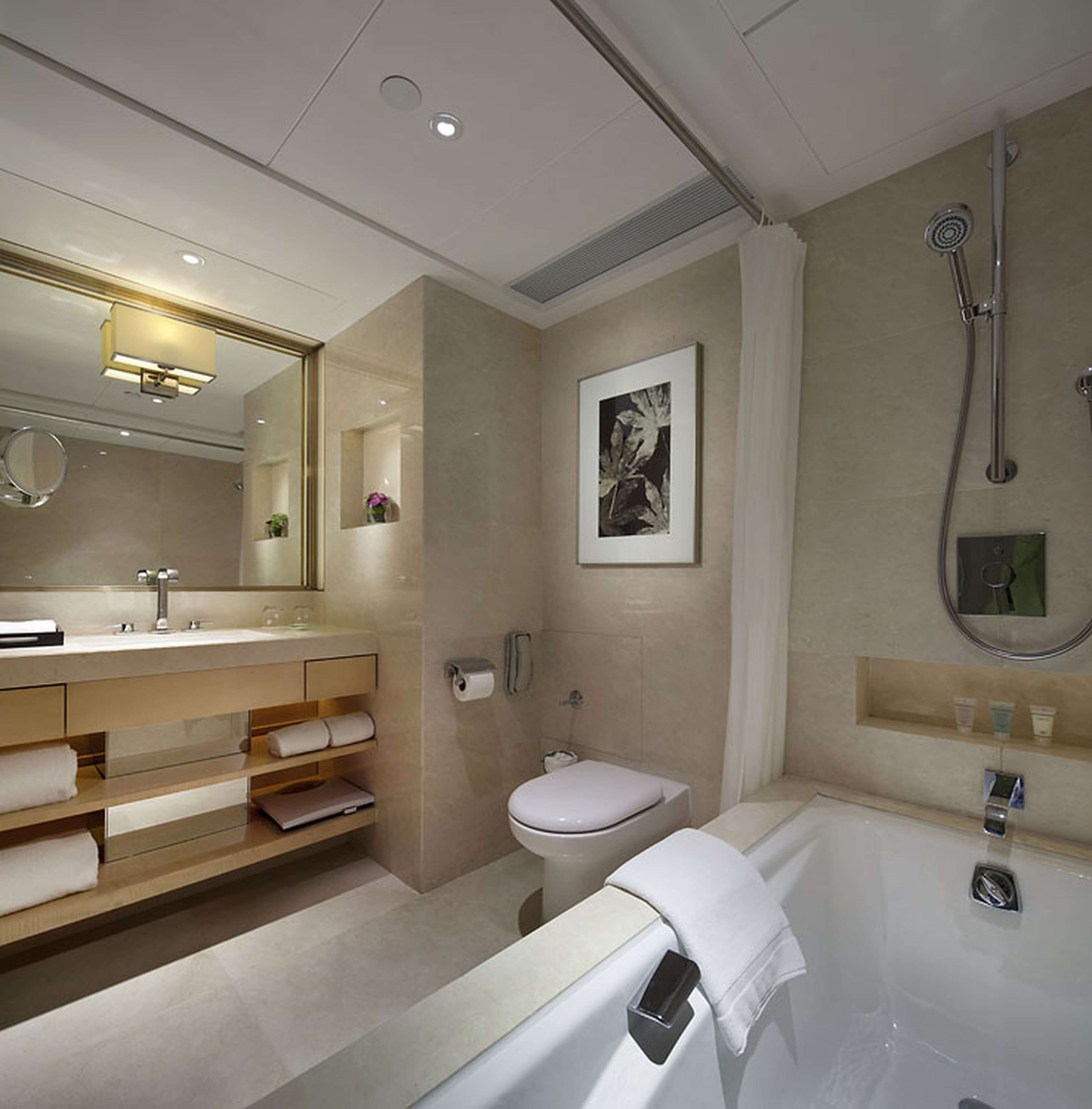 A modern bathroom with a vanity, toilet, and bathtub.