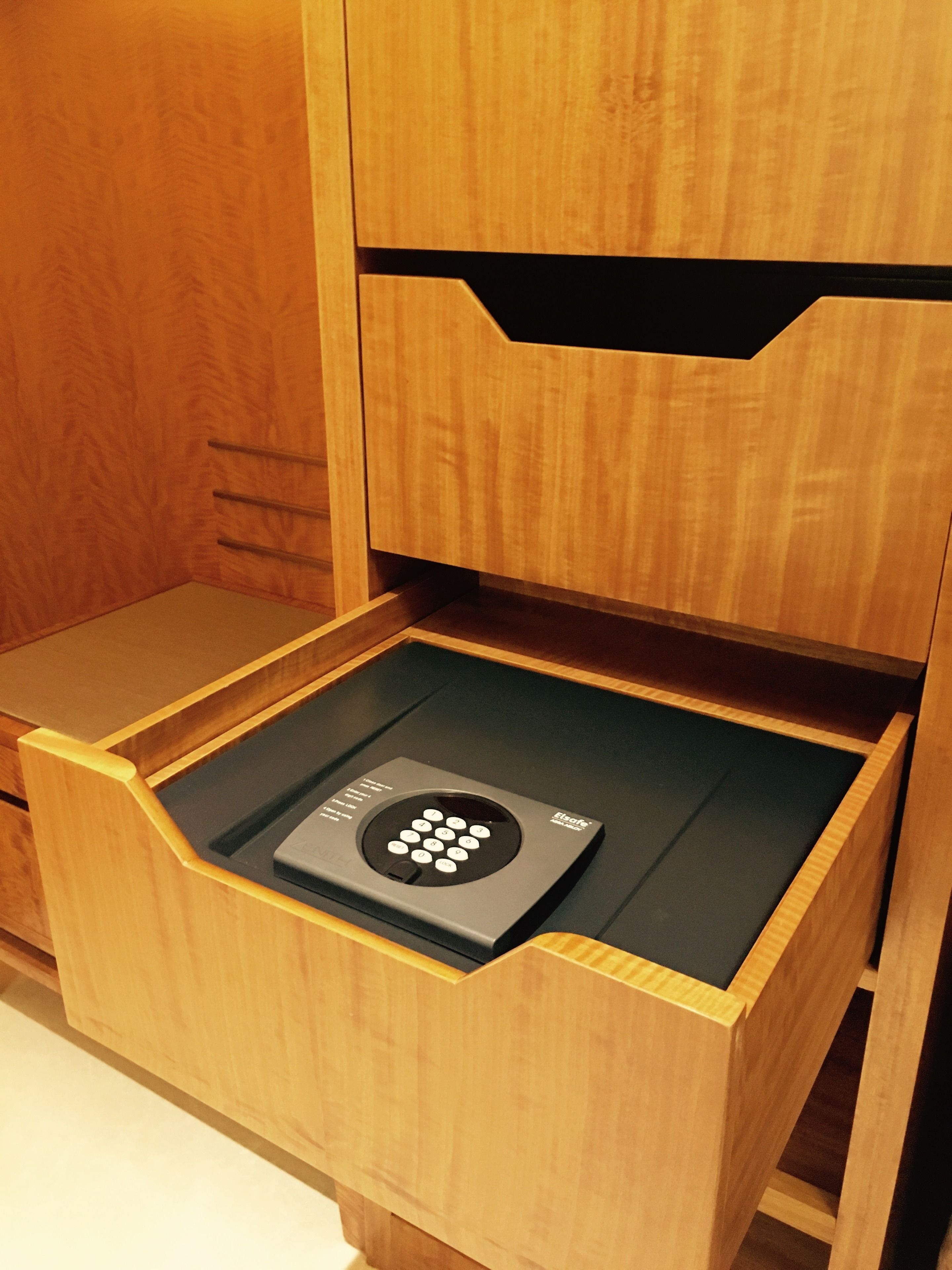 A wooden drawer with a black electronic device inside.