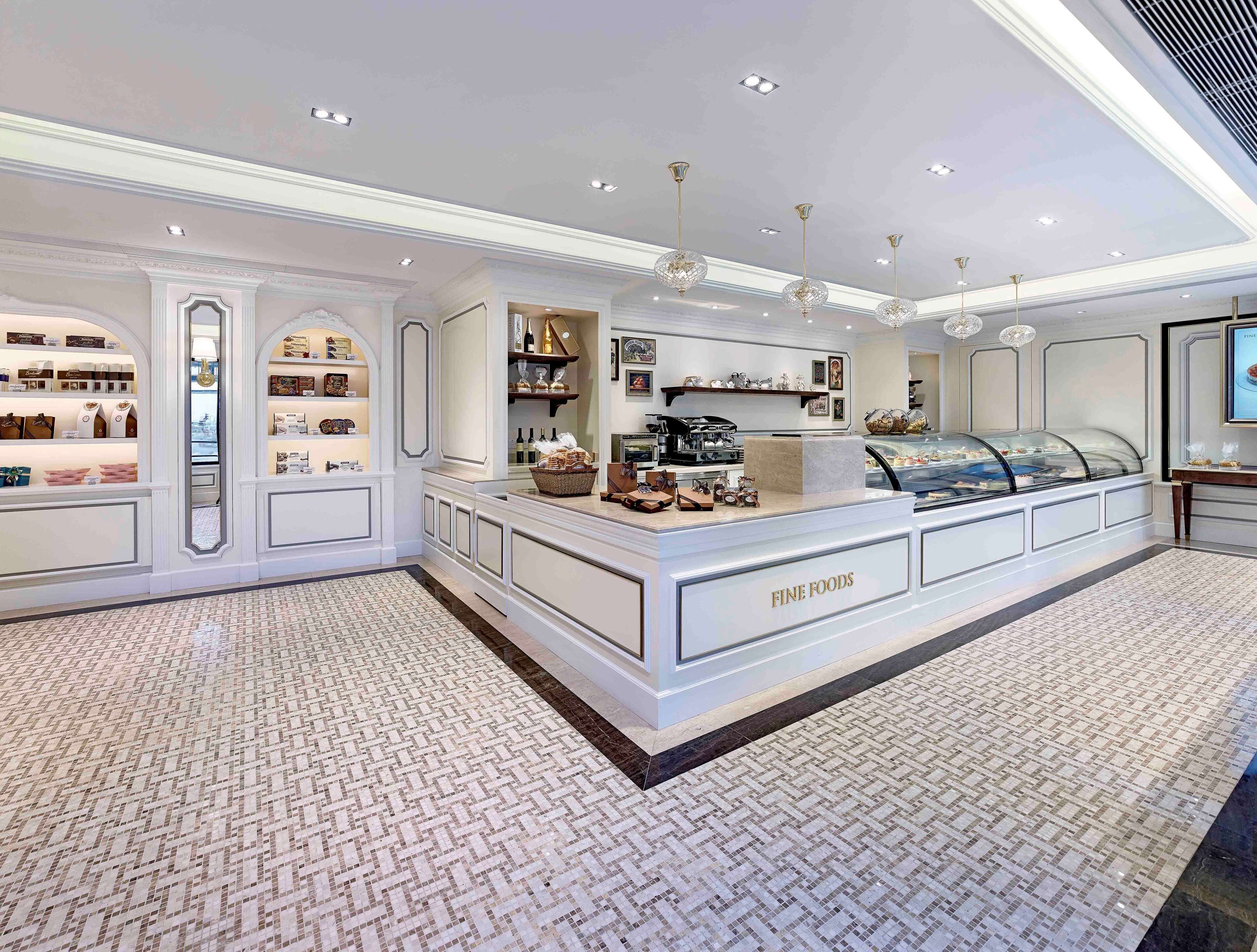A luxurious fine foods display area with a marble counter, elegant lighting, and a patterned floor.