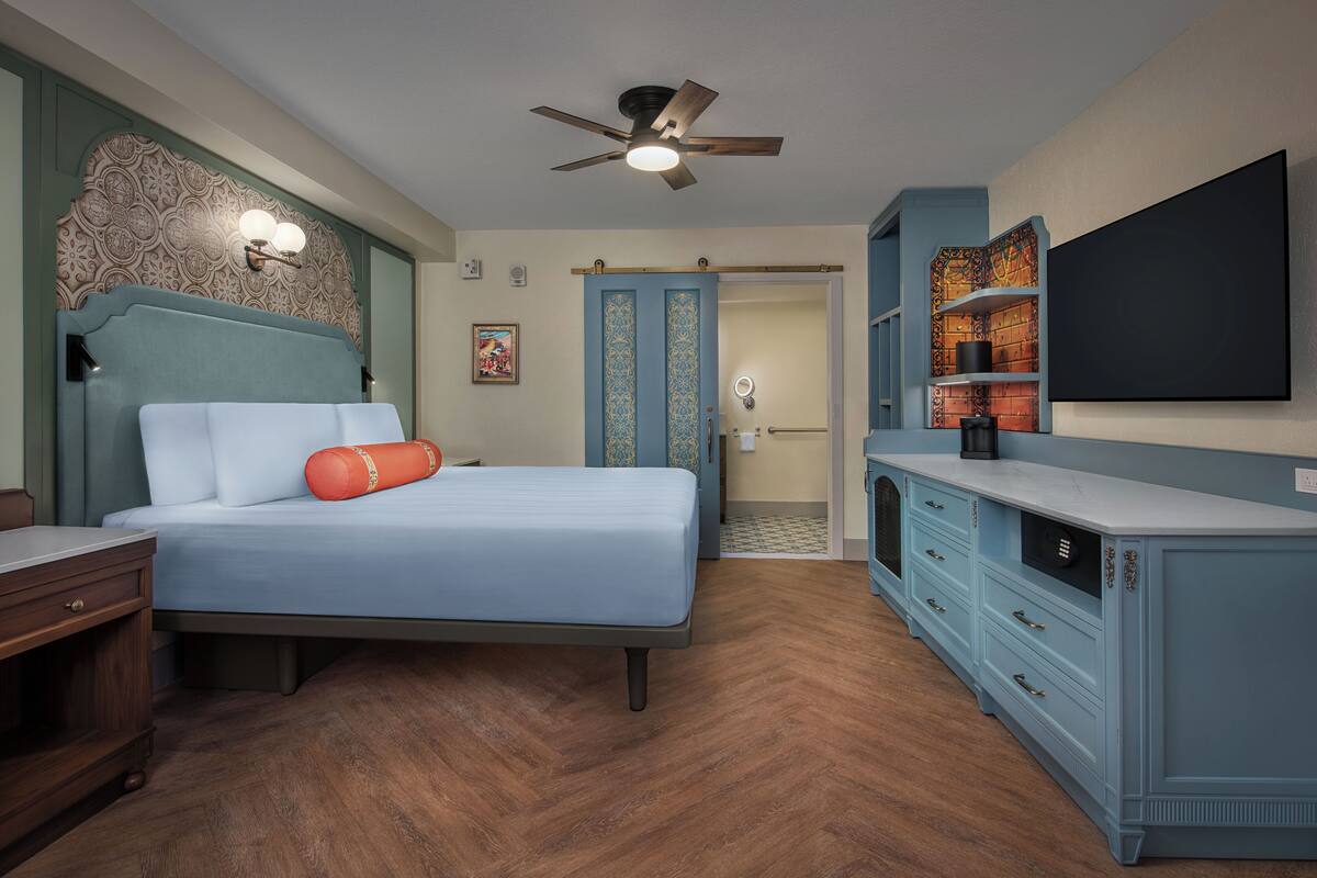 A bedroom with a bed, nightstand, dresser, and a ceiling fan.