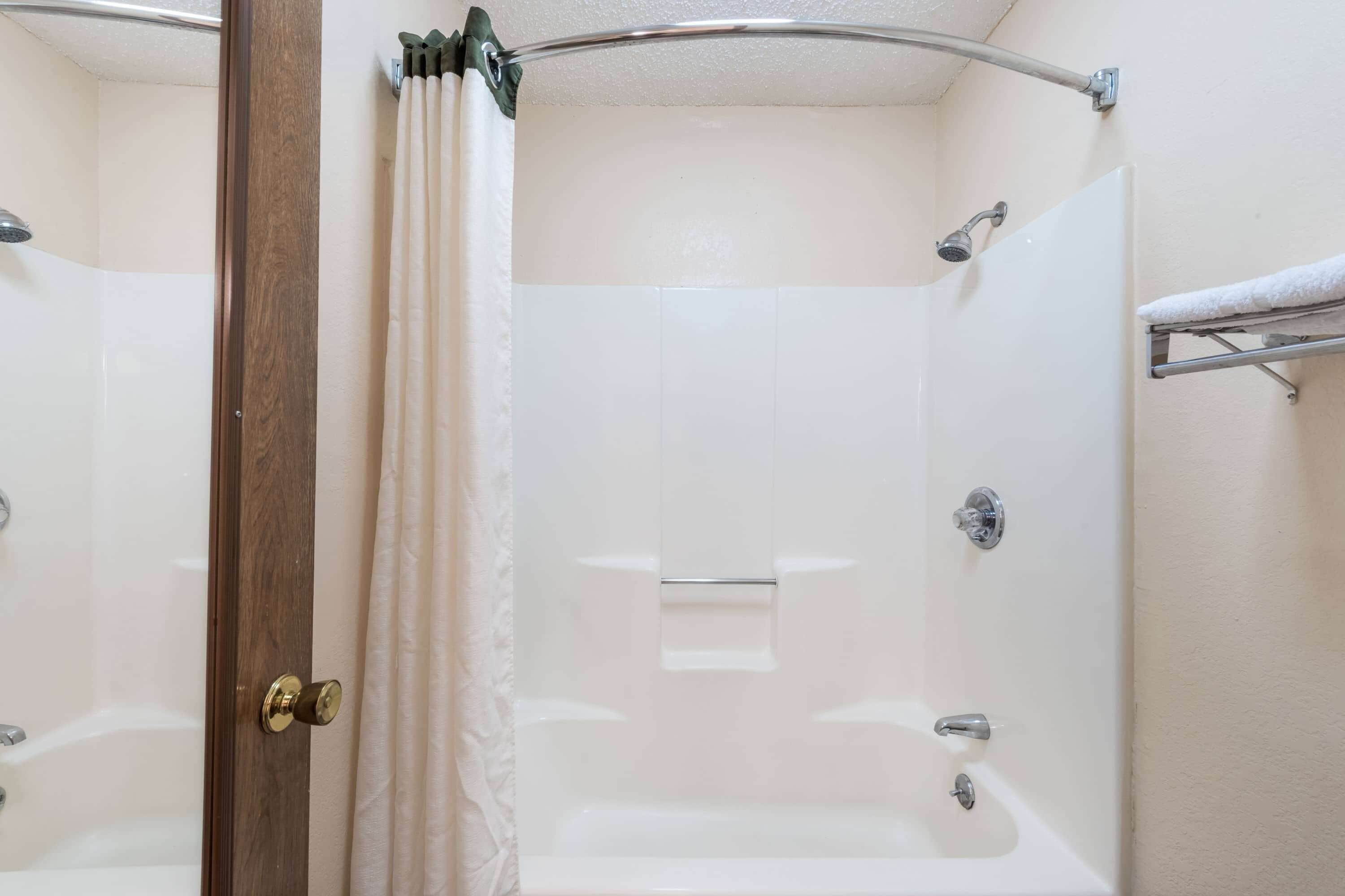 Une salle de bain avec une douche, une baignoire et un porte-serviettes.