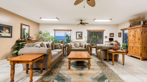 A spacious living room with a sofa set, wooden coffee table, and a ceiling fan. - Super 8 by Wyndham Waco/Mall area TX (Waco)