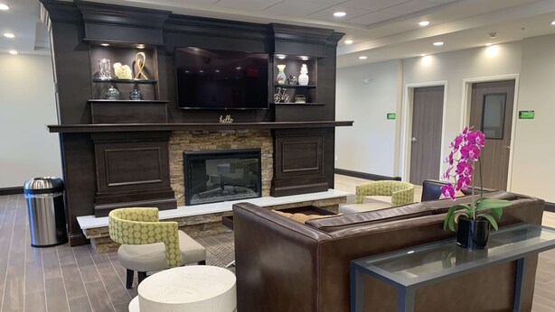 A lobby with a fireplace, seating area, and a reception desk.