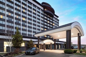 A modern hotel with a large entrance, multiple floors, and a covered parking area. - Courtyard by Marriott Denver Cherry Creek (Denver)