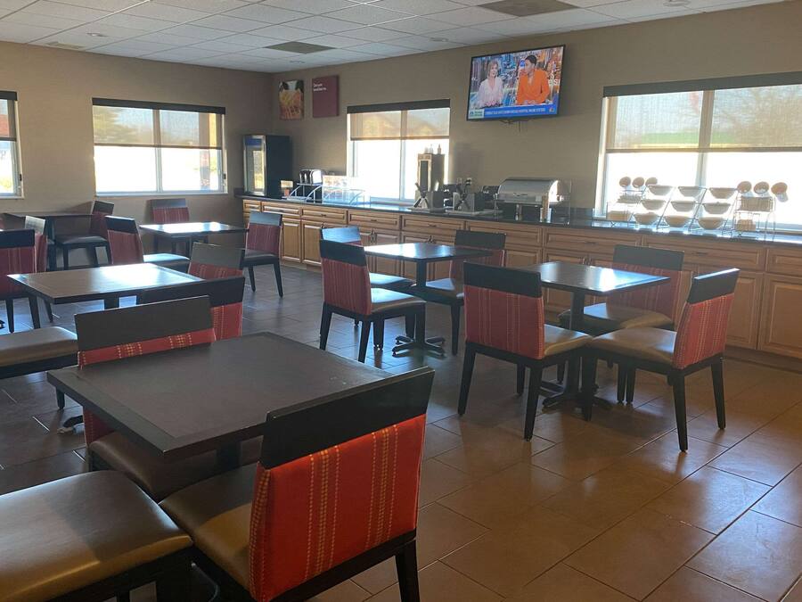A restaurant with booths and tables, a TV screen, and a counter with a coffee machine.