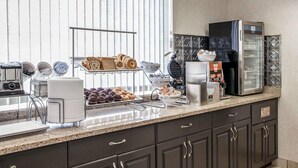 Una cocina con cafetera, tostadora y refrigerador.