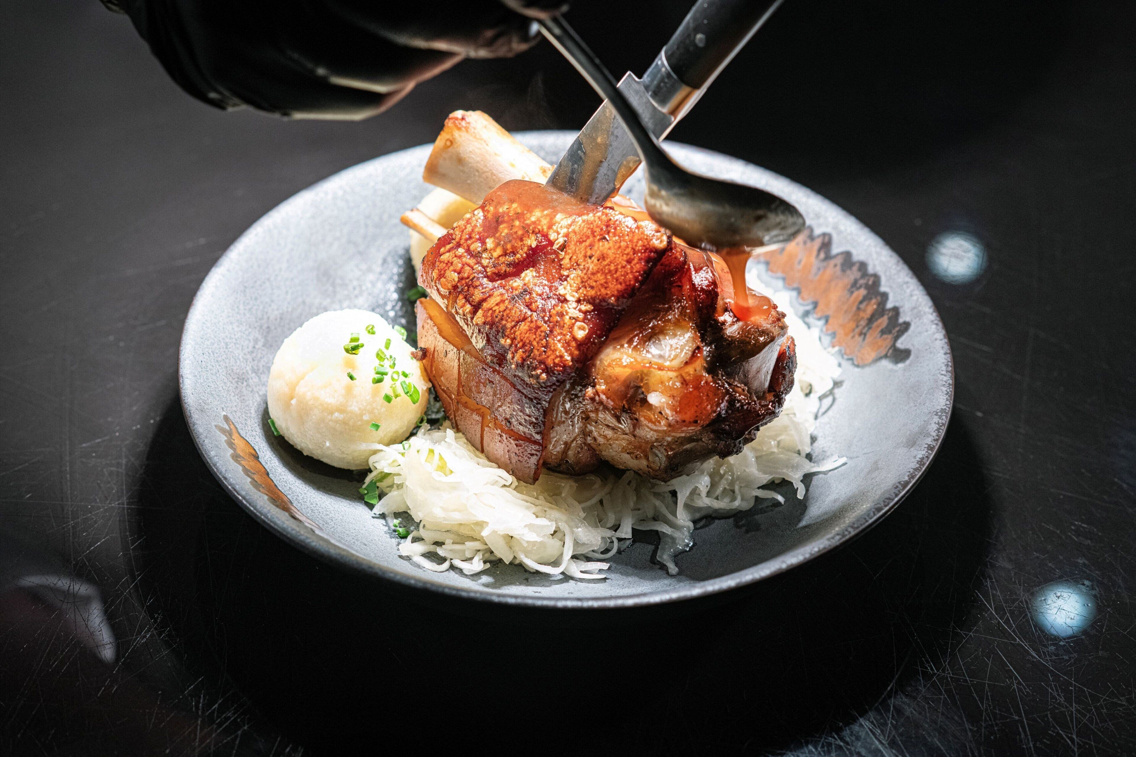 A plate with a roasted pork chop, a boiled egg, and sauerkraut.