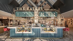 Un área moderna de cocina y bar con un tablero de menú que muestra café y favoritos de Starbucks.