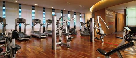 A gym with treadmills, elliptical machines, and weight equipment.