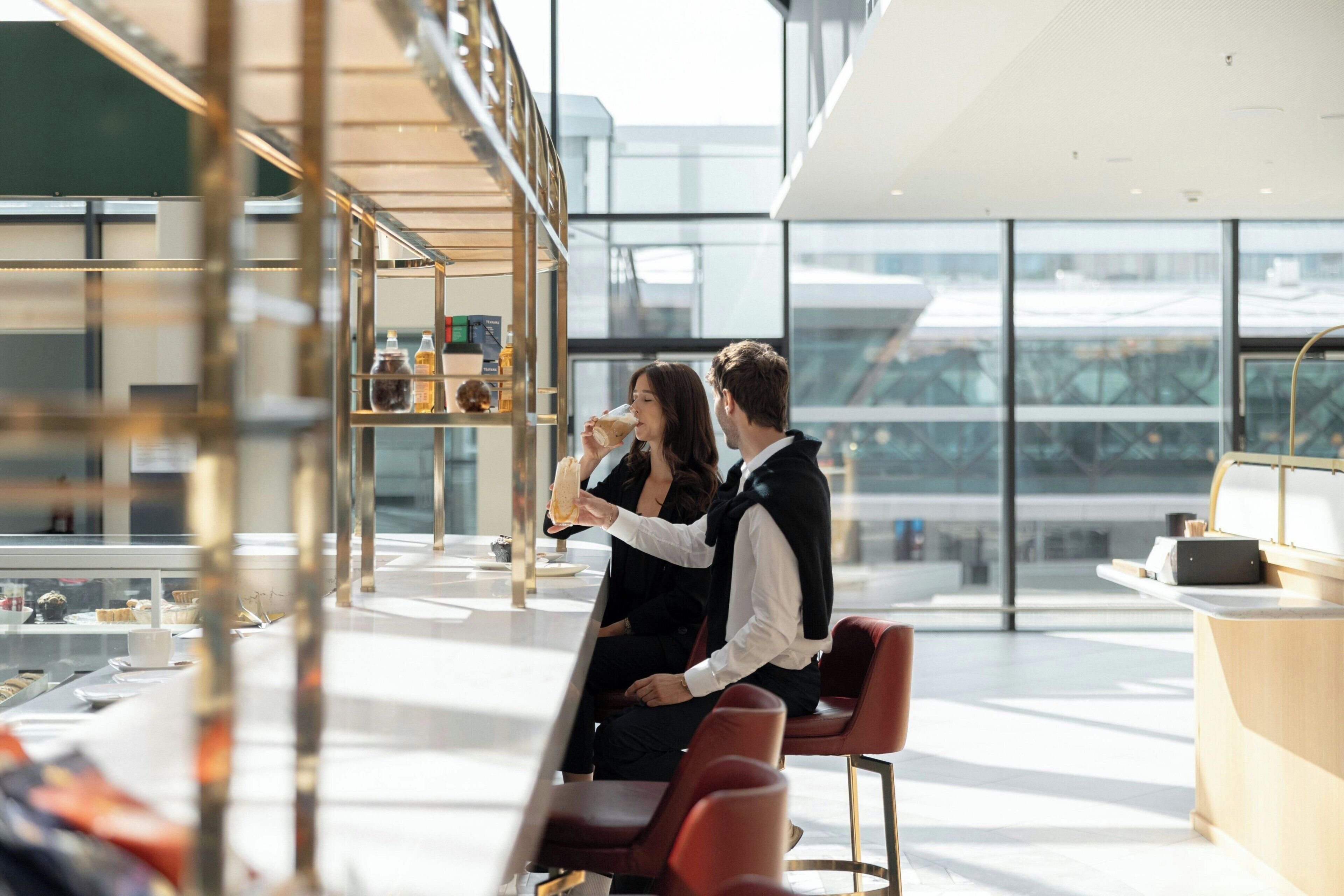 Ein modernes Interieur mit Glastrennwand, einer Theke und Sitzbereichen.