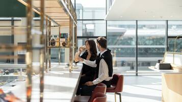 Ein modernes Interieur mit Glastrennwand, einer Theke und Sitzbereichen.