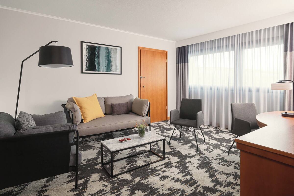 A modern living room with a sofa, coffee table, and chairs.
