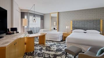 Una habitación de hotel con una cama grande, un escritorio con una silla, un televisor y un espejo.
