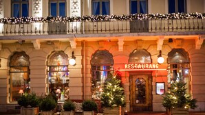 A restaurant with a classic facade, arched windows, and Christmas decorations. - Hôtel Eggers (Gothenburg)