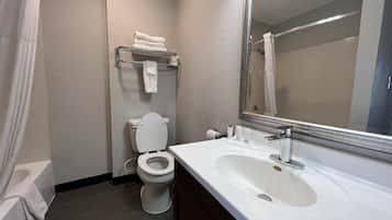 A bathroom with a white toilet, a sink with a mirror, and a shower curtain.