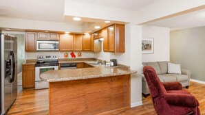 Una cocina moderna con armarios de madera, encimera de granito y una isla integrada.