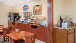 Rincón para desayunar con cafetera, microondas y mostrador de alimentos.