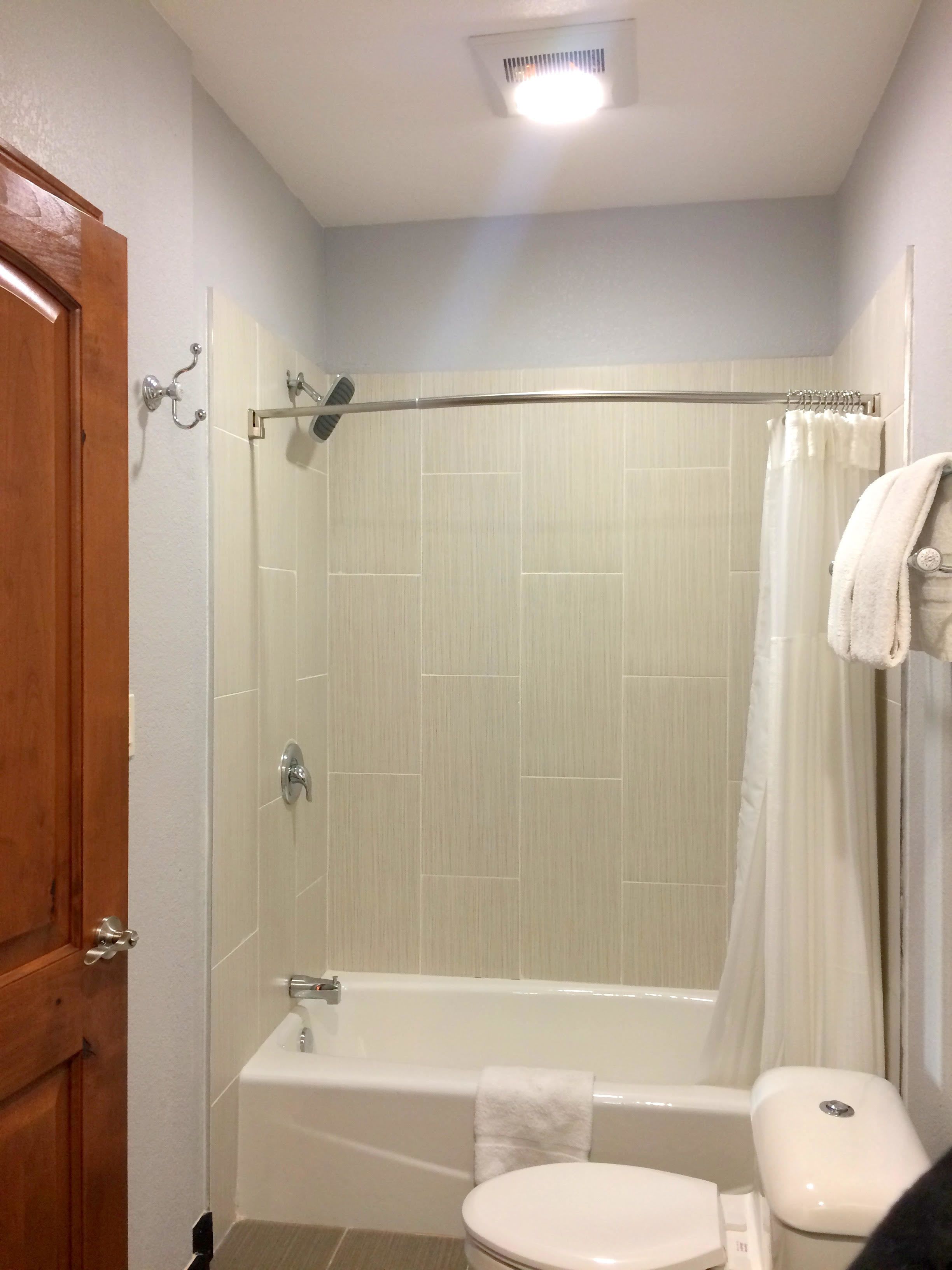 Un baño con bañera, inodoro y cortina de ducha.