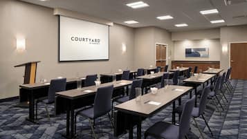 Un salón de conferencias con una gran pantalla que muestra