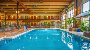 An indoor swimming pool with a wooden ceiling and multiple balconies. - Wyndham Garden York (York)