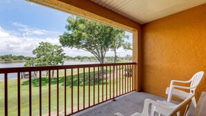 A balcony with a view of a lake and trees, featuring a concrete floor and a railing. - Quality Inn & Suites Mt Dora North (Mount Dora)