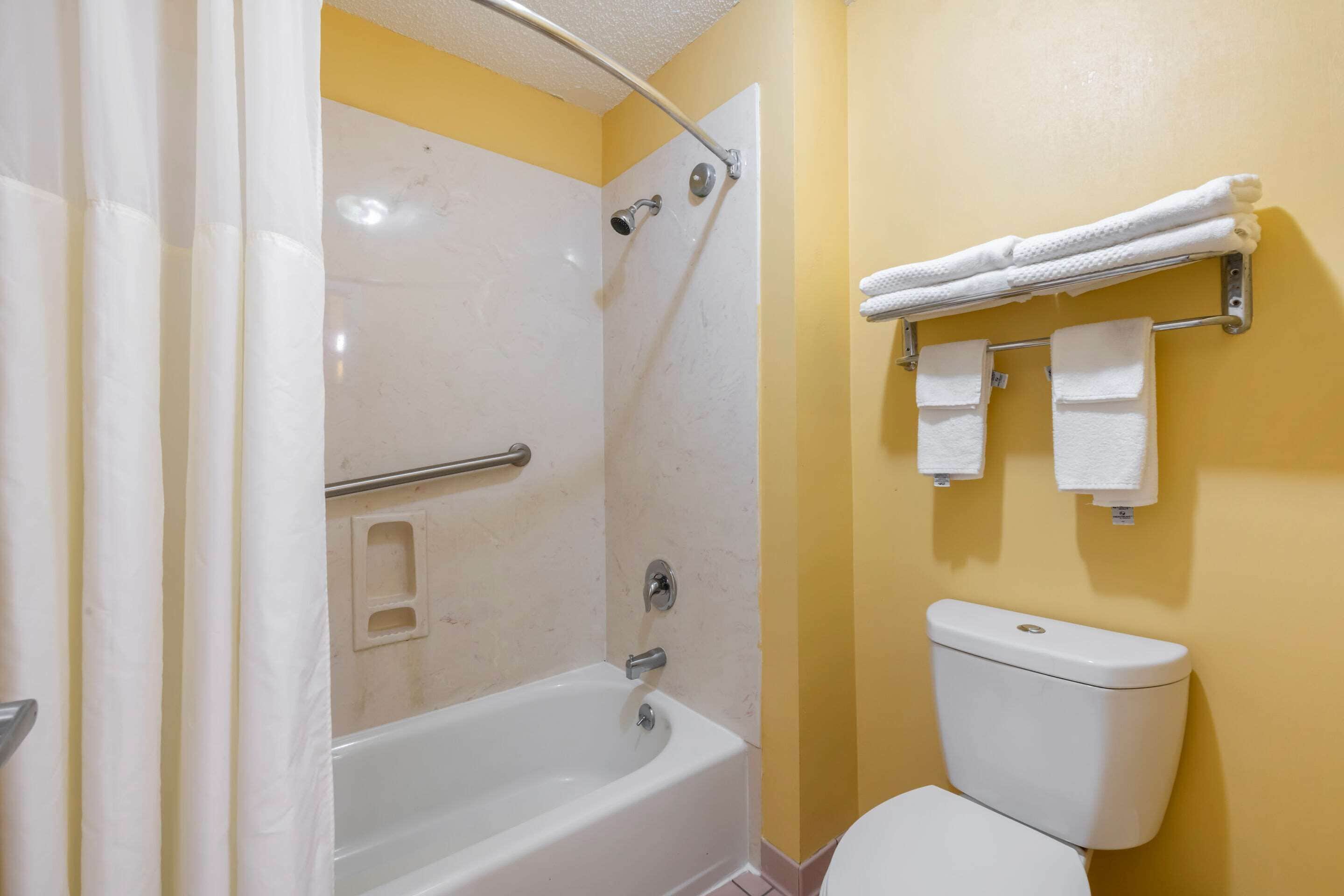 A bathroom with a bathtub, shower, and toilet.