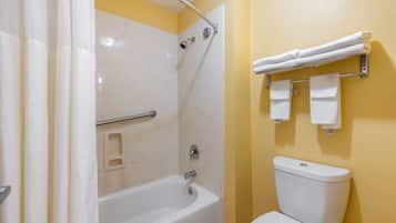 A bathroom with a bathtub, shower, and toilet.