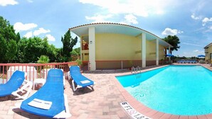 A pool area with lounge chairs, a covered seating area, and a clear blue pool. - Quality Inn & Suites Mt Dora North (Mount Dora)