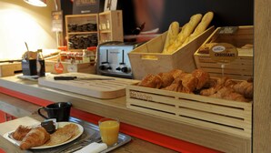 A breakfast counter with croissants, a coffee machine, and a menu board. - ibis Paris Vaugirard Porte de Versailles (Paris)