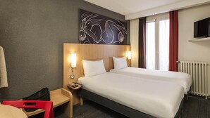 A hotel room with two beds, a desk, a chair, a TV, and a window with curtains. - ibis Paris Vaugirard Porte de Versailles (Paris)