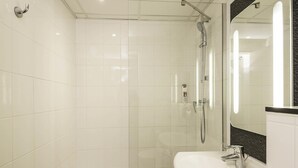 A modern bathroom with a glass-enclosed shower, a white sink, and a large mirror. - ibis Paris Vaugirard Porte de Versailles (Paris)