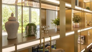 A modern interior with a wooden desk, a potted plant, and a decorative item. - Holiday Inn Guildford by IHG (Guildford)