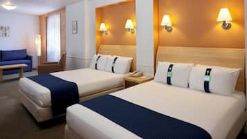 Une chambre d’hôtel avec deux lits, un bureau, une chaise et un canapé.