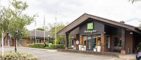Un hôtel Holiday Inn avec une façade en briques et un logo vert.