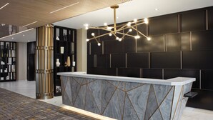 A modern reception area with a marble counter, geometric wall panels, and a patterned floor. - Delta Hotels by Marriott Toronto Markham (Markham)