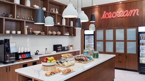 A modern ice cream shop with a marble counter, wooden shelves, and hanging pendant lights. - Delta Hotels by Marriott Toronto Markham (Markham)