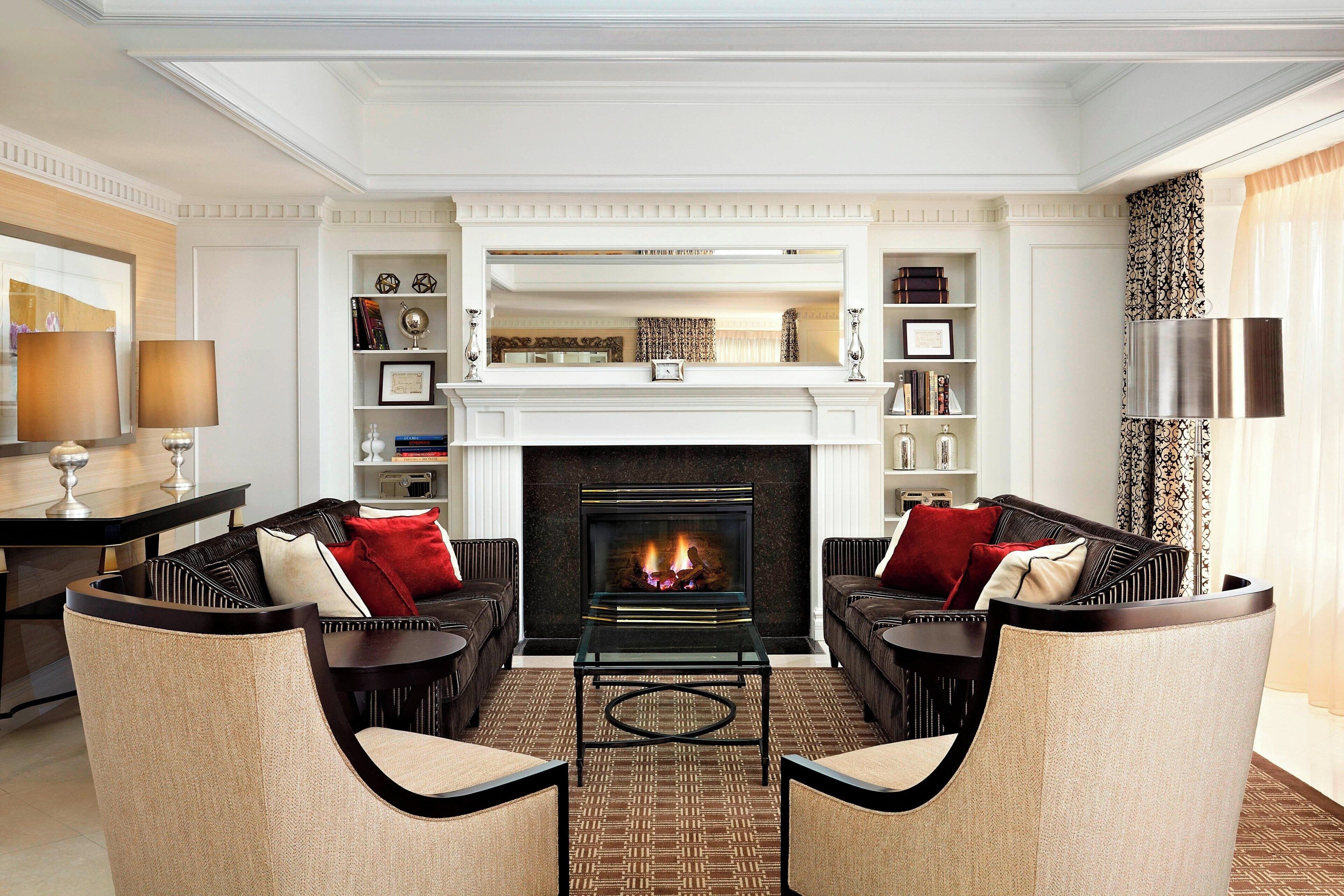 A modern living room with a fireplace, two sofas, a coffee table, and a bookshelf.
