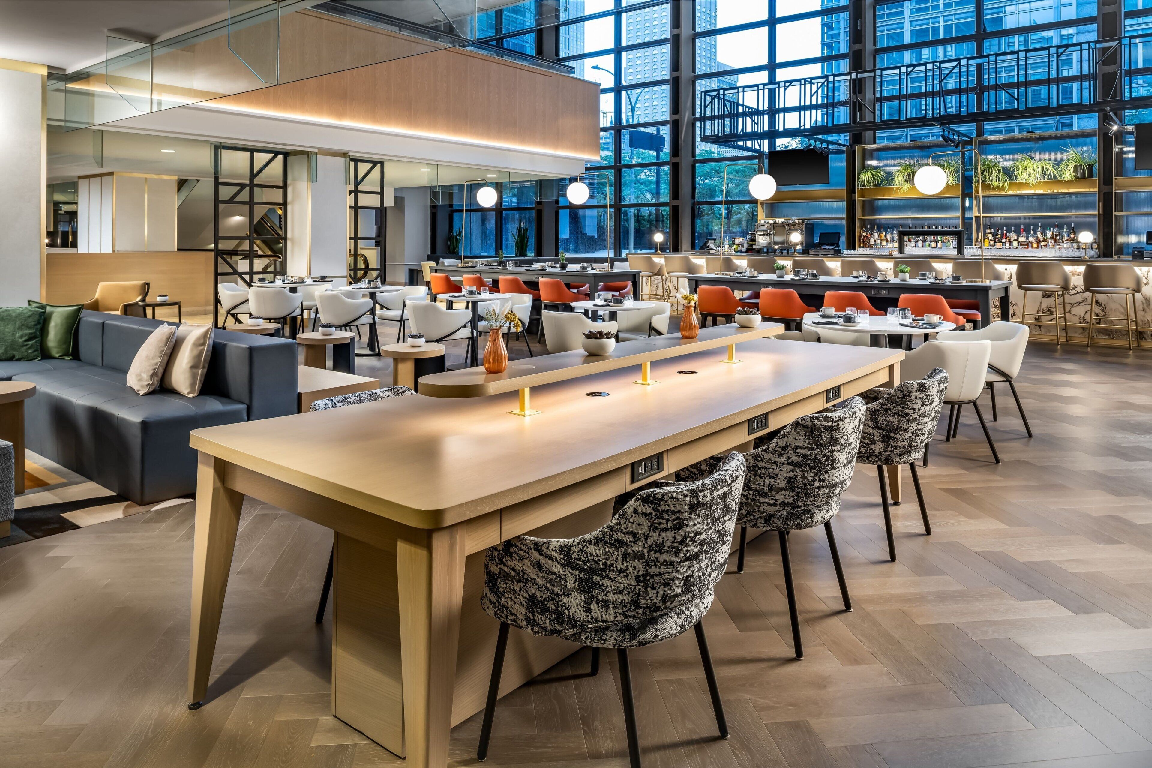Ein modernes Interieur mit einer zentralen Bar, Sitzgelegenheiten und großen Fenstern mit Blick auf die Stadt.
