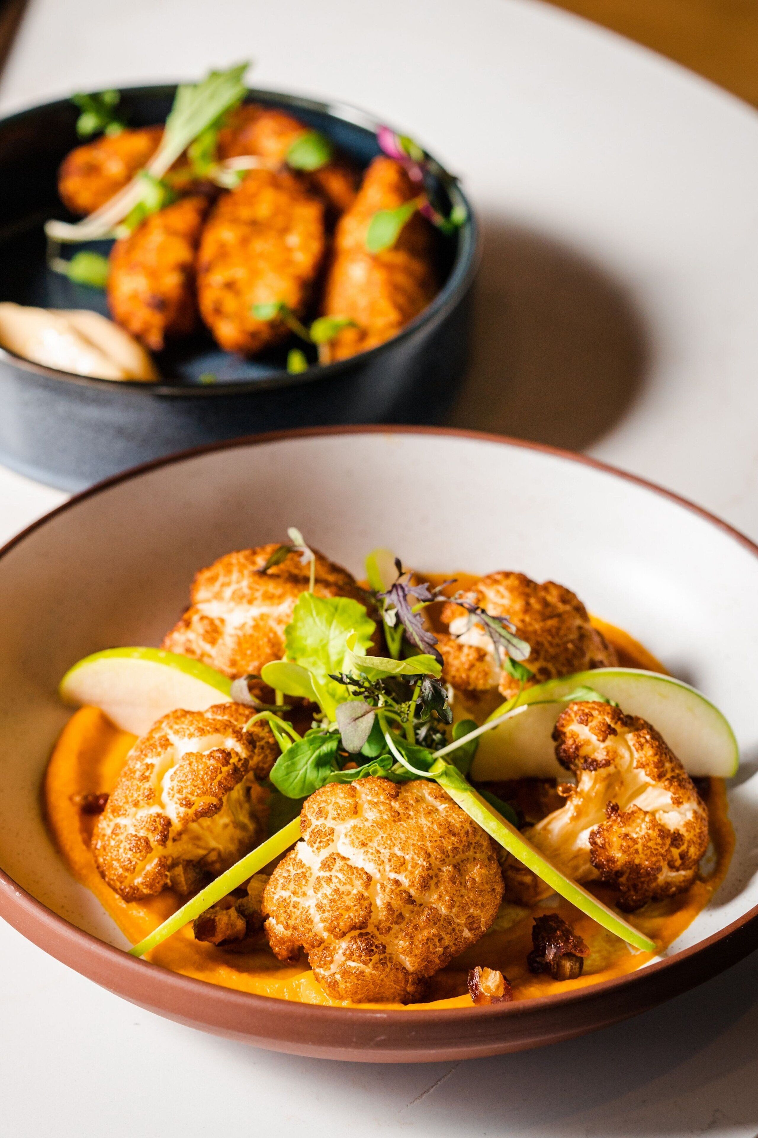 A bowl of food with cauliflower and greens.