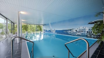Una piscina interior con vistas a la ciudad costera.