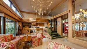 A spacious lobby with patterned sofas, a wooden reception desk, and a staircase leading to upper floors. - Ringhotel Seehof Berlin (Berlin)