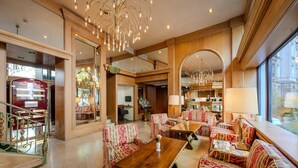 A spacious lobby with patterned sofas, a wooden coffee table, and a chandelier. - Ringhotel Seehof Berlin (Berlin)