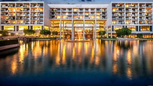 A multi-story hotel with balconies, a central courtyard, and a reflective pool. - JW Marriott Desert Springs Resort & Spa (Palm Desert)