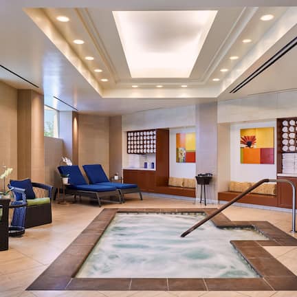 A spa area with a hot tub, lounge chairs, and a reception desk.