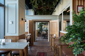 An interior with a herringbone floor, wooden furniture, and hanging plants. - Elite Hotel Marina Plaza (Helsingborg)