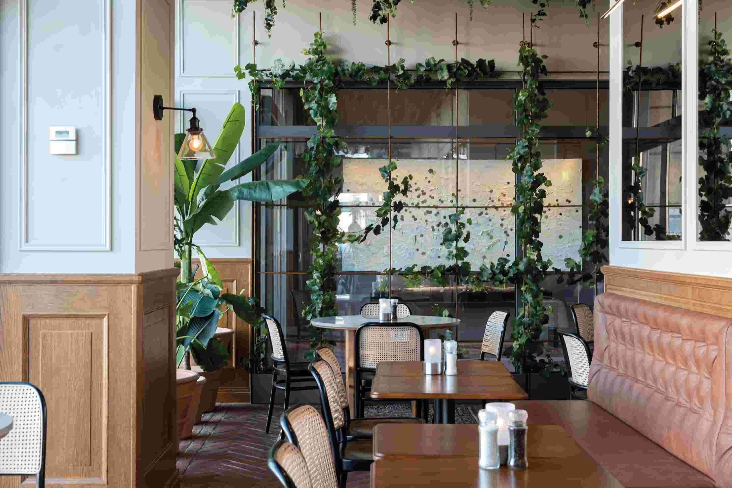 A restaurant interior with wooden paneling, wicker chairs, and tables.