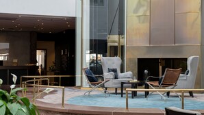 Een moderne binnenzitplaats met een zwembad, met een combinatie van lounge fauteuils en een kleine tafel.