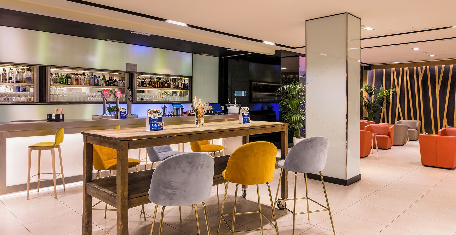 A bar area with stools, a counter, and a seating area with chairs.